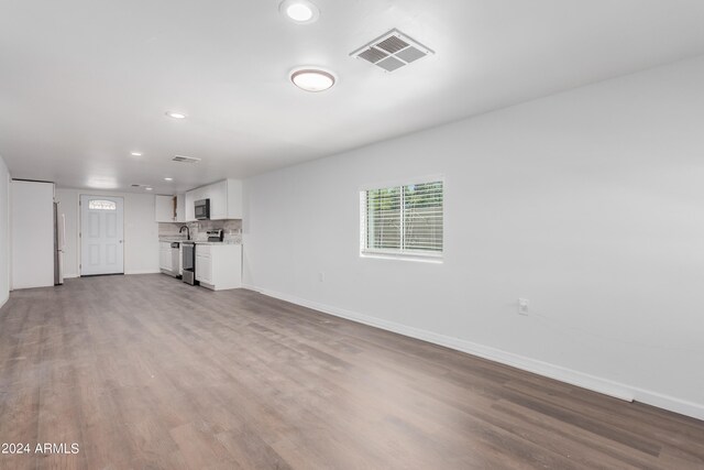 unfurnished living room with hardwood / wood-style flooring