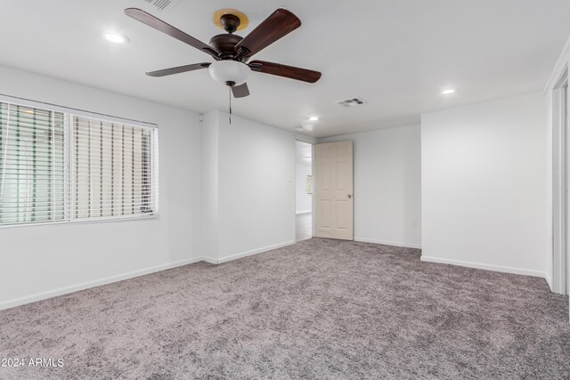 spare room featuring carpet and ceiling fan