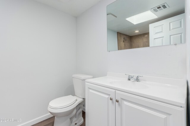 bathroom featuring hardwood / wood-style flooring, oversized vanity, and toilet