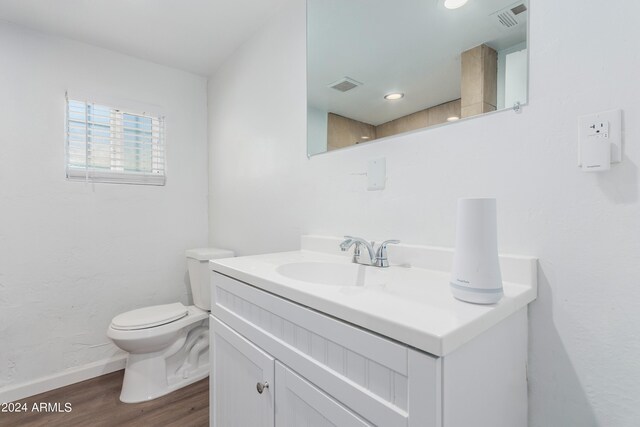 bathroom with toilet, wood-type flooring, and oversized vanity