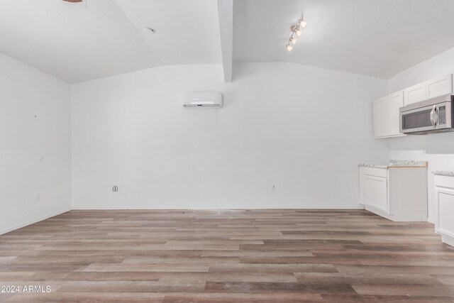 interior space with hardwood / wood-style flooring, vaulted ceiling with beams, and rail lighting