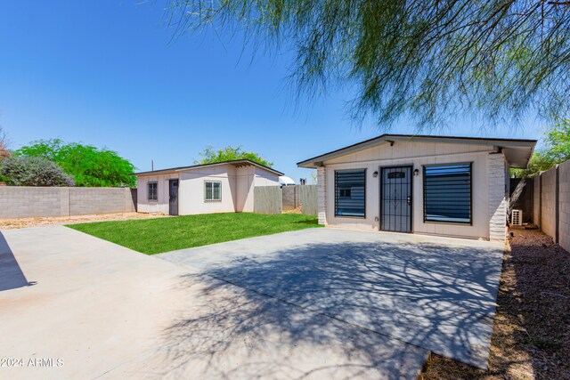 rear view of house with a patio area and a lawn