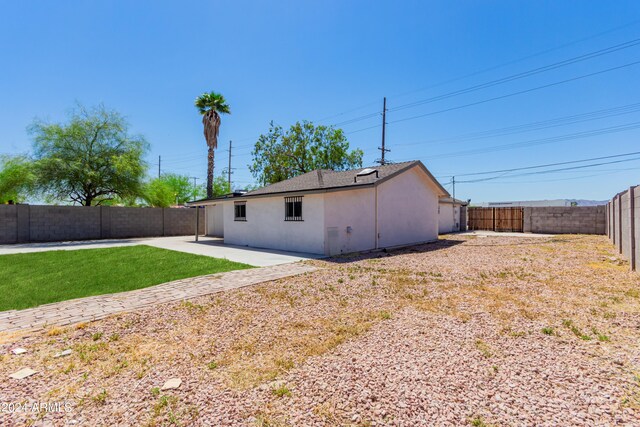 rear view of house featuring a yard and a patio