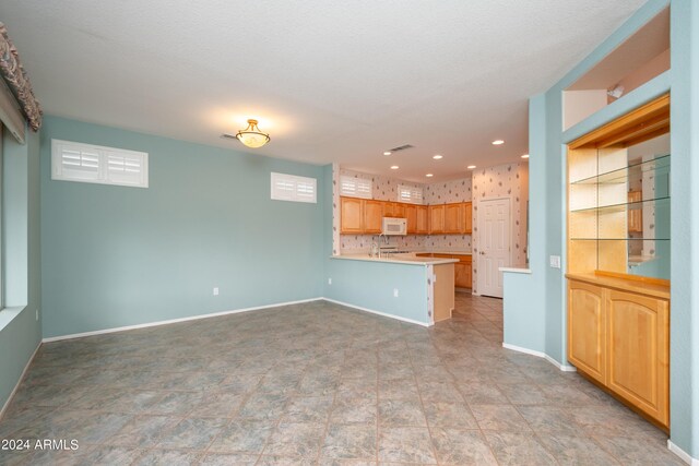 unfurnished living room with a textured ceiling and light tile patterned flooring