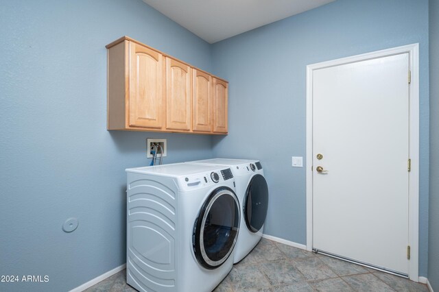 laundry room with washer and clothes dryer and cabinets