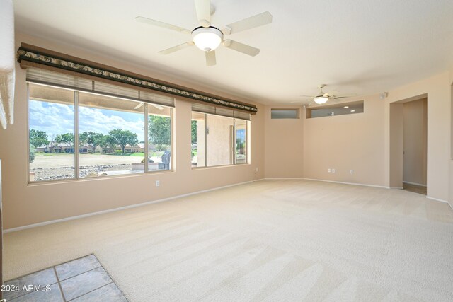 carpeted spare room with ceiling fan