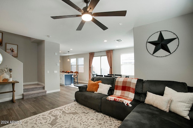 living room with a wealth of natural light, light hardwood / wood-style floors, and ceiling fan