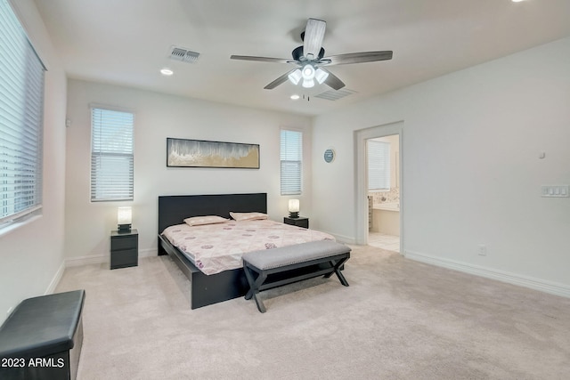 bedroom with light carpet, ensuite bath, and ceiling fan