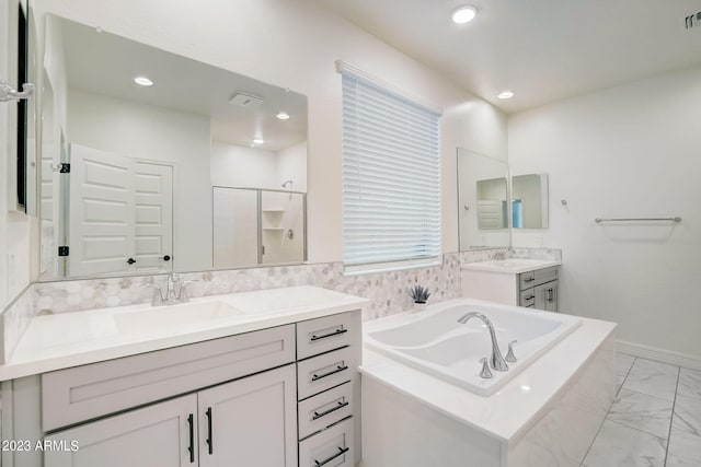 bathroom featuring tiled tub, tile floors, and double sink vanity