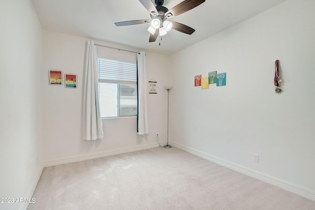 spare room featuring ceiling fan and light colored carpet