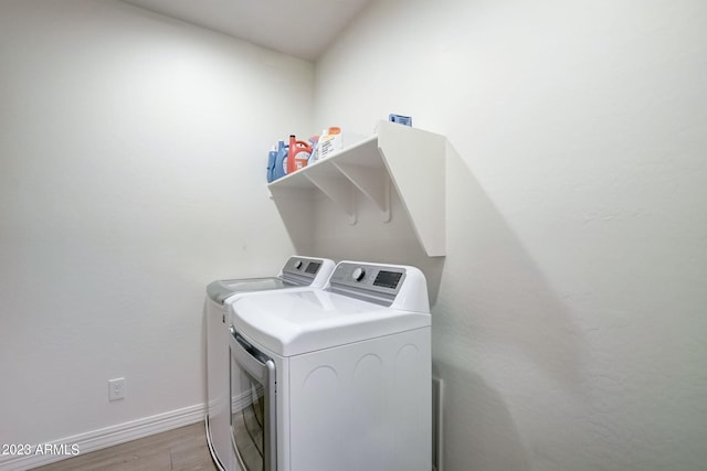 laundry area with hardwood / wood-style flooring and washing machine and dryer