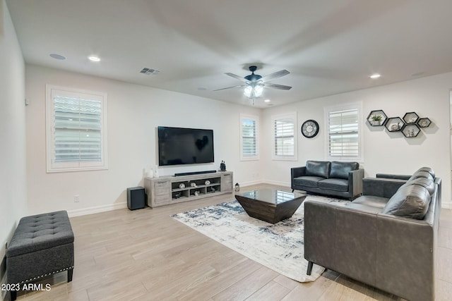 living room with ceiling fan, a wealth of natural light, and light hardwood / wood-style floors