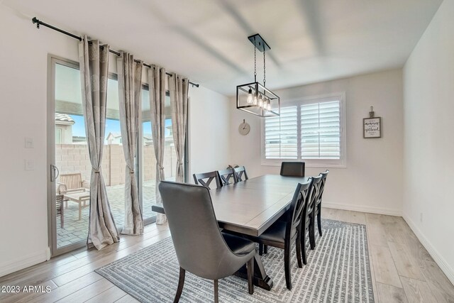 dining area featuring a notable chandelier and light wood-type flooring