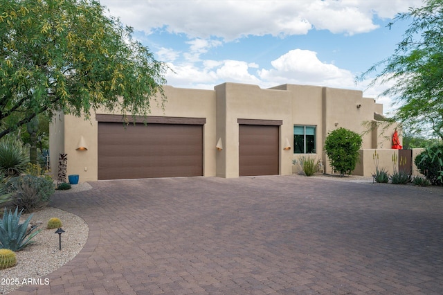 8400 E Dixileta Dr Unit 153, Scottsdale, AZ 85266 - pueblo revival-style home with an attached garage, decorative driveway, and stucco siding