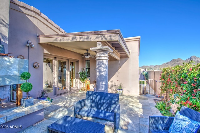 view of patio featuring a gate, ceiling fan, fence, and a mountain view