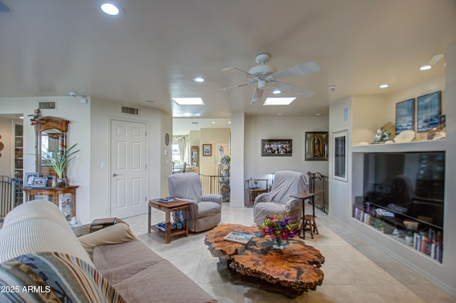 living room featuring ceiling fan, visible vents, recessed lighting, and a skylight