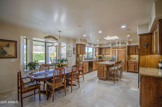 dining area with recessed lighting, baseboards, light tile patterned flooring, a skylight, and a notable chandelier