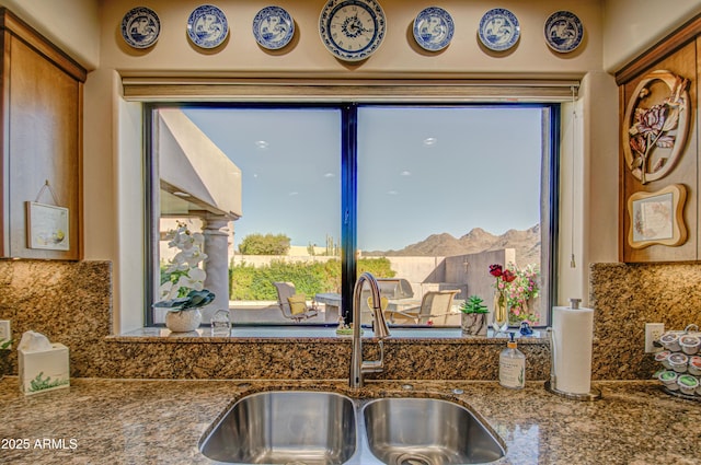 room details featuring stone counters, a sink, and decorative backsplash