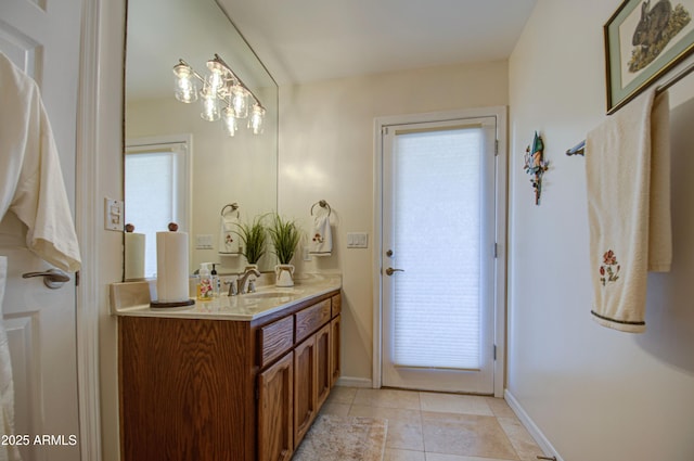 bathroom with double vanity, a wealth of natural light, a sink, and tile patterned flooring