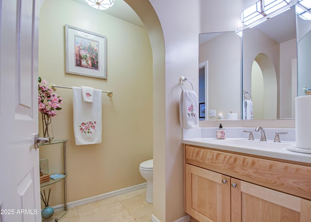 bathroom featuring baseboards, toilet, tile patterned flooring, and vanity