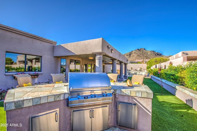 view of patio / terrace with a mountain view, fence, area for grilling, and a ceiling fan
