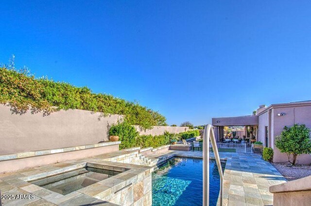 view of pool with a fenced backyard, an in ground hot tub, a patio, and a fenced in pool