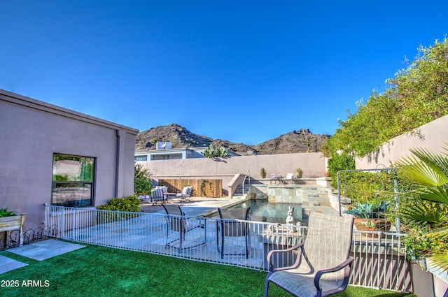 view of patio / terrace featuring a mountain view, a fenced backyard, and a fenced in pool