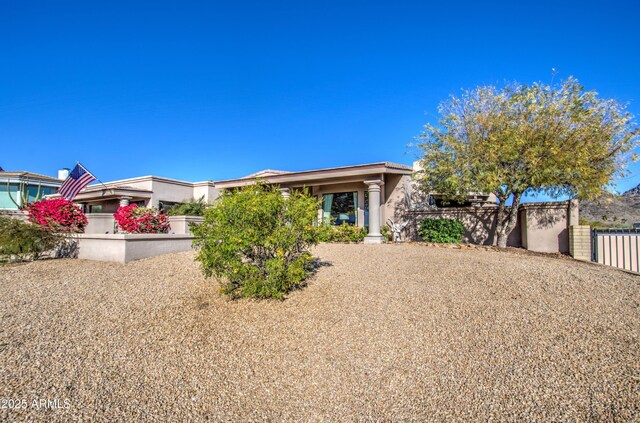 view of front of home with stucco siding and fence