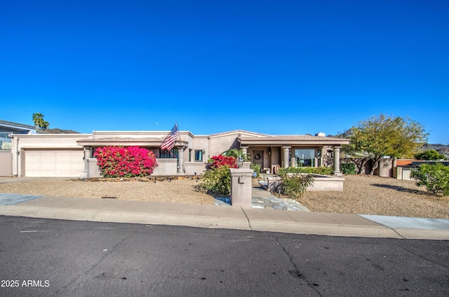 view of front of property with a garage, concrete driveway, and stucco siding