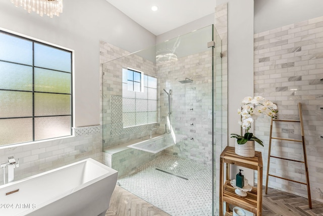 bathroom featuring plus walk in shower, parquet flooring, a wealth of natural light, and tile walls