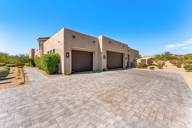 8742 E Villa Cassandra Dr, Scottsdale, AZ 85266 - view of side of property featuring decorative driveway, stucco siding, and a garage