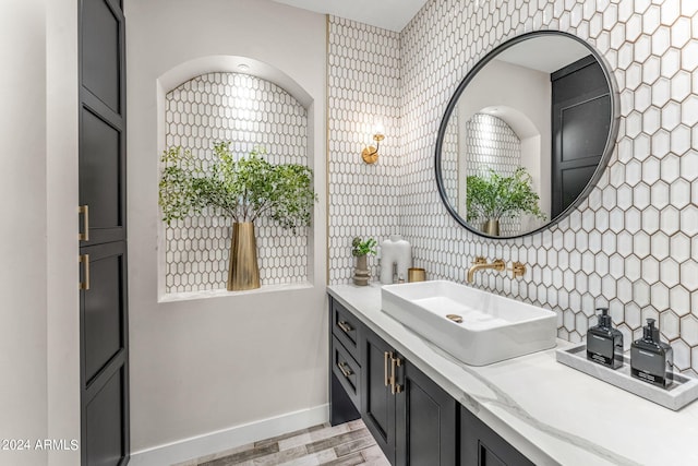 bathroom with wood-type flooring, vanity, and tile walls