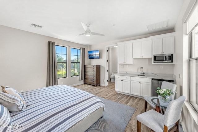 bedroom featuring ceiling fan, sink, and light hardwood / wood-style floors