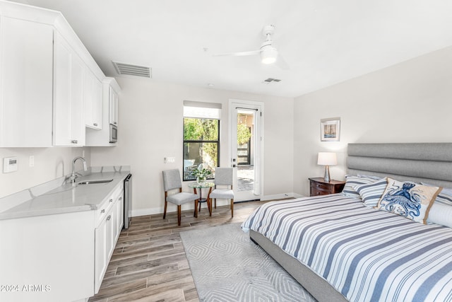 bedroom with ceiling fan, access to exterior, light wood-type flooring, and sink