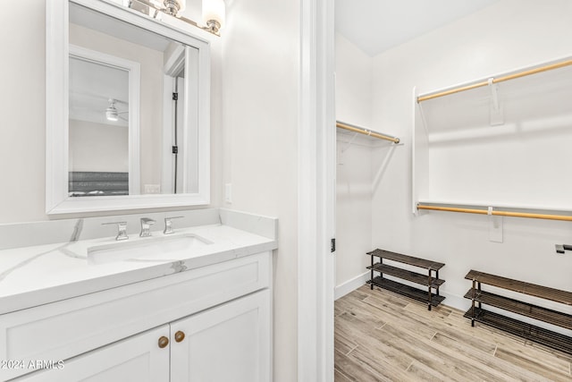 bathroom with hardwood / wood-style flooring, vanity, and ceiling fan