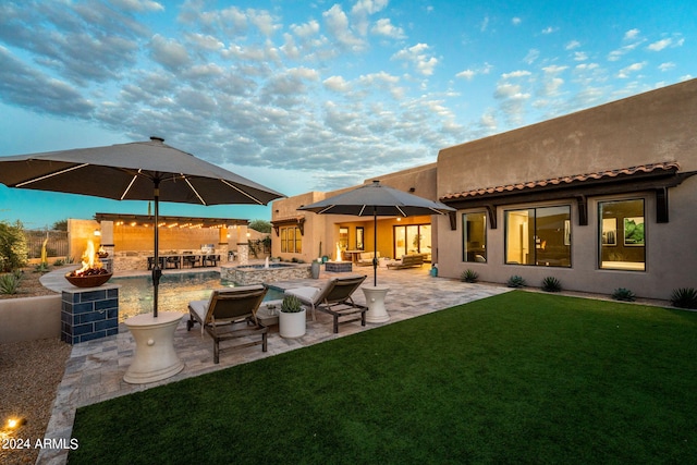 8742 E Villa Cassandra Dr, Scottsdale, AZ 85266 - back of property featuring an outdoor fire pit, stucco siding, a tile roof, a lawn, and a patio area
