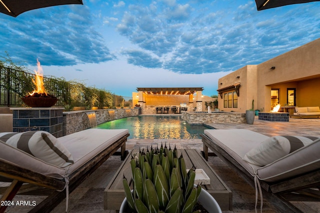 view of swimming pool featuring an outdoor living space with a fire pit and a patio