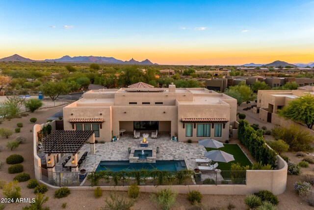 8742 E Villa Cassandra Dr, Scottsdale, AZ 85266 - back of house at dusk featuring stucco siding, a mountain view, and a fenced backyard