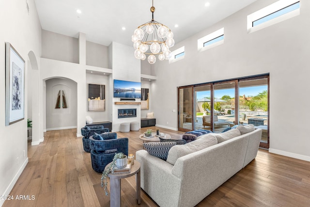 living room with a high ceiling, wood-type flooring, and a chandelier