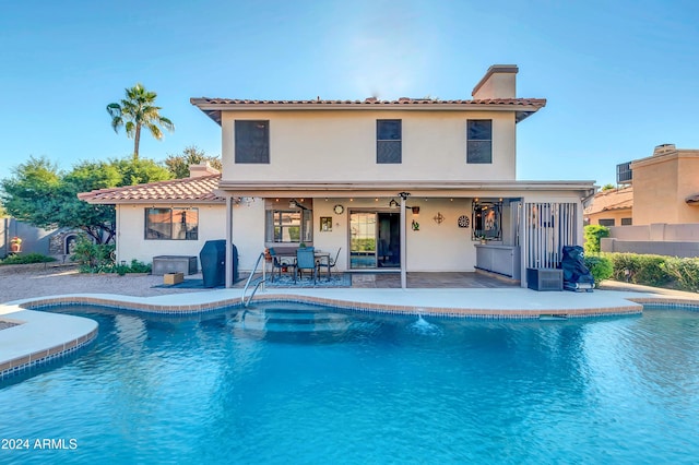 back of property featuring a fenced in pool and a patio area