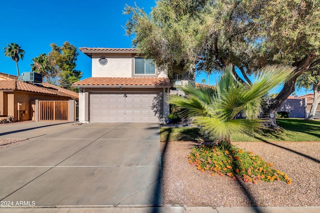 mediterranean / spanish-style house featuring central air condition unit and a garage