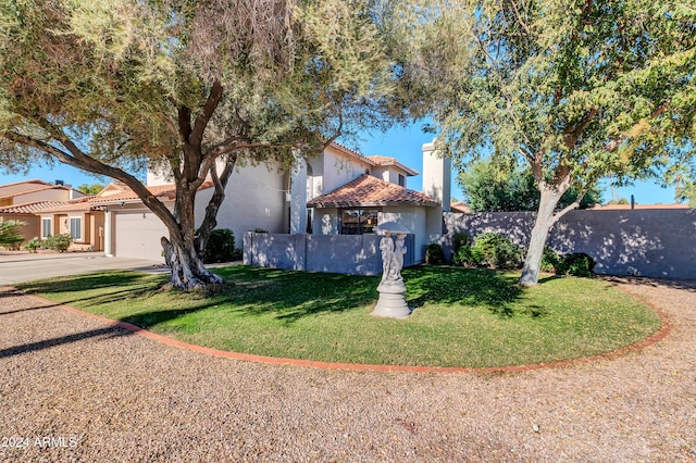 mediterranean / spanish house featuring a garage and a front yard