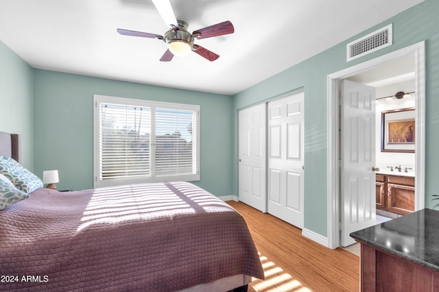 bedroom with ceiling fan, a closet, connected bathroom, and light hardwood / wood-style flooring