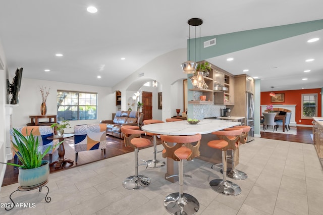 dining area featuring light hardwood / wood-style floors and vaulted ceiling