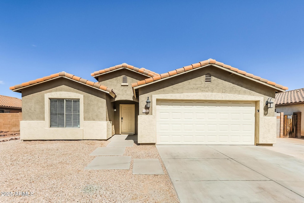 25674 W Northern Lights Way, Buckeye, AZ 85326 - view of front facade with driveway, fence, a tiled roof, a garage, and stucco siding