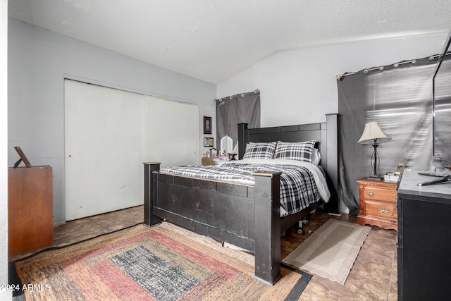 bedroom featuring a textured ceiling, a closet, and lofted ceiling