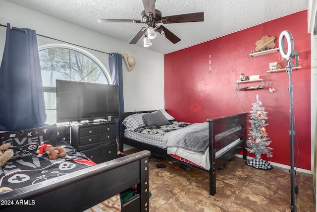 bedroom with ceiling fan and a textured ceiling