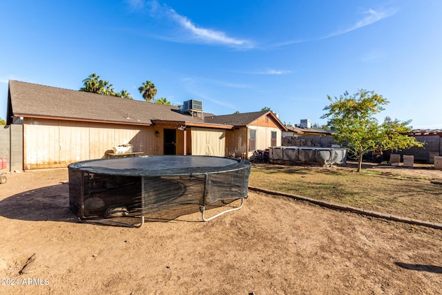 back of property with cooling unit and a covered pool