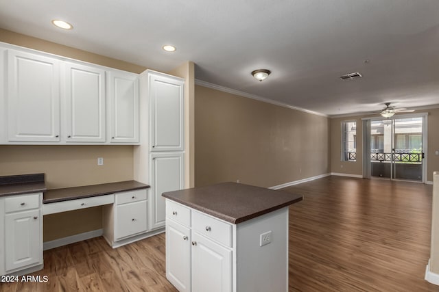 kitchen with ceiling fan, light hardwood / wood-style floors, white cabinetry, crown molding, and built in desk