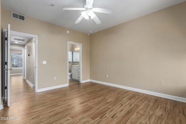 unfurnished bedroom with hardwood / wood-style floors, connected bathroom, and ceiling fan